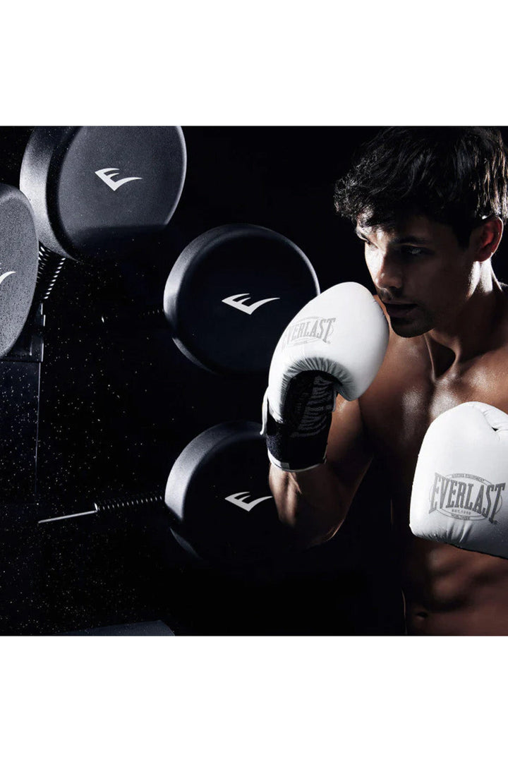 man with white boxing gloves training with boxing tree